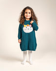 Toddler wearing Pompom Wonderland Cotton Knitted Sweater Dress in dark green with a white cat design and colorful pom-poms. Long-sleeved, cozy, soft cotton ideal for casual fall and winter outfits.